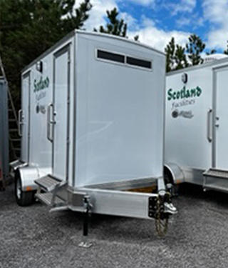 branded double portable restroom on a trailer
